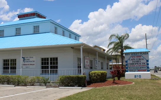 Exterior of Cape Coral Family Chiropractic with a blue roof and roadside clinic sign.